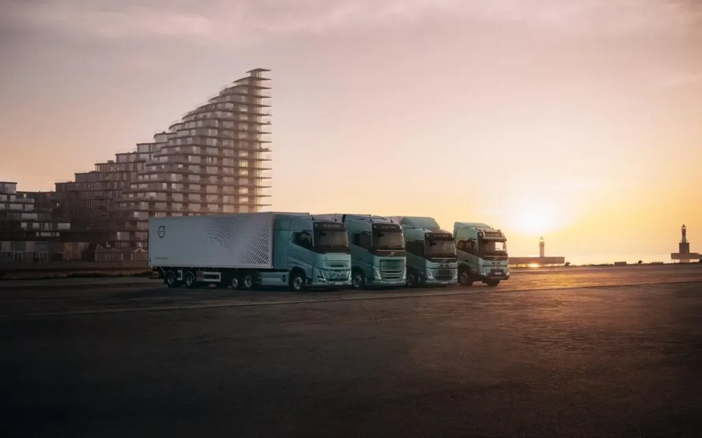 A lineup of four modern light-green Volvo electric heavy-duty commercial trucks. (Photo: Volvo Trucks)