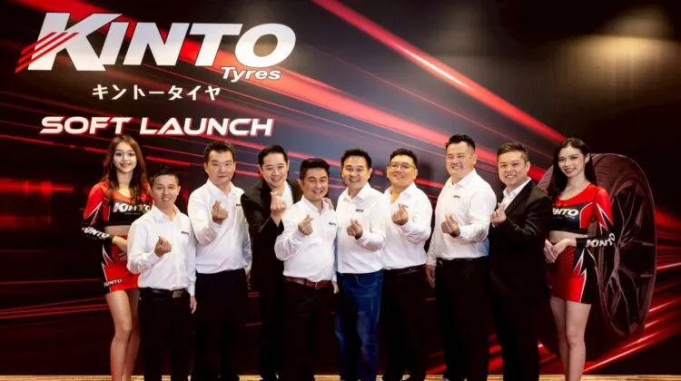 Kinto Tyres executives and brand ambassadors making heart hand gestures in front of a red and black Kinto Tyres Soft Launch backdrop.